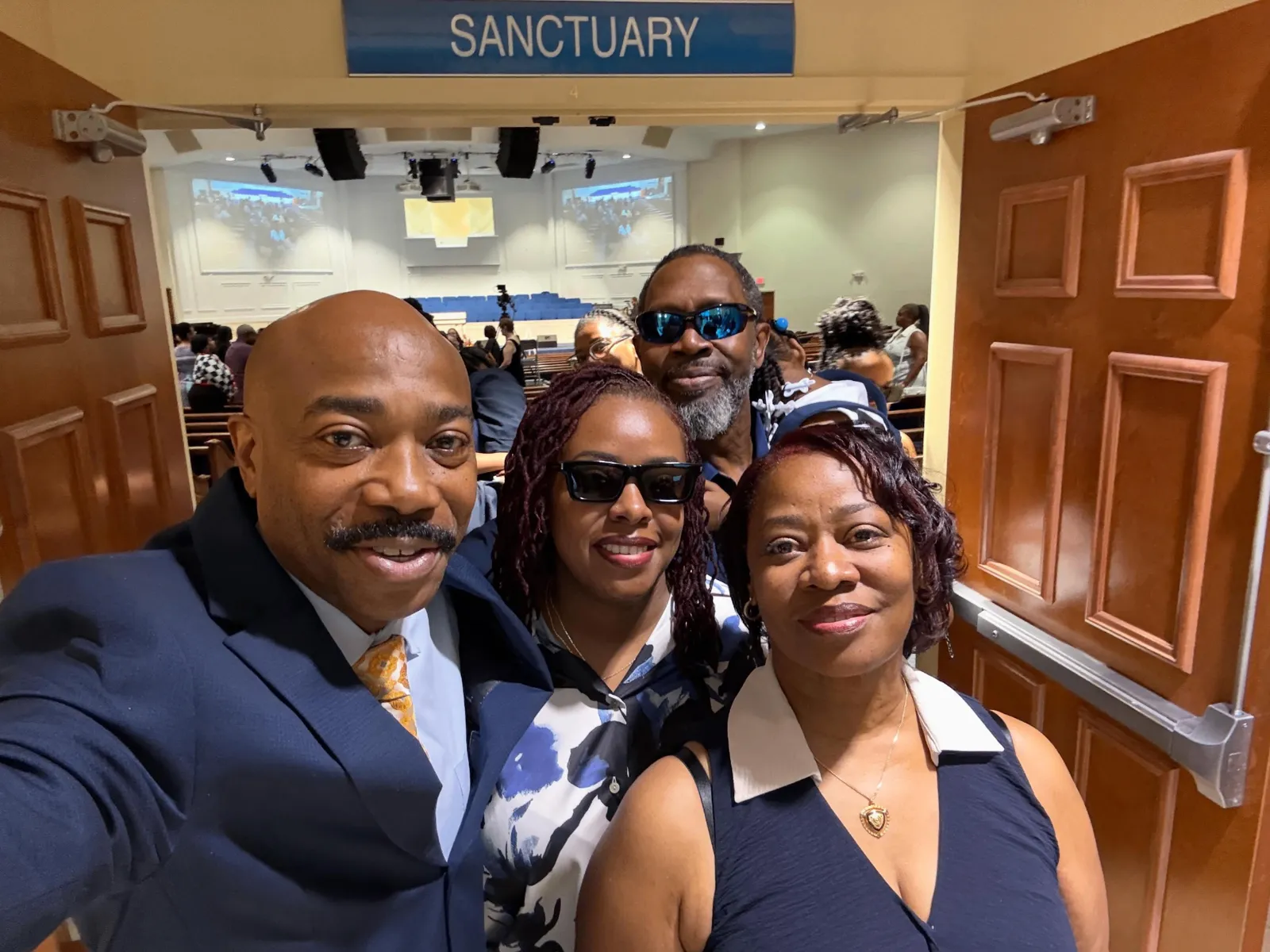 Pastor group selfie with members at the sanctuary entrance