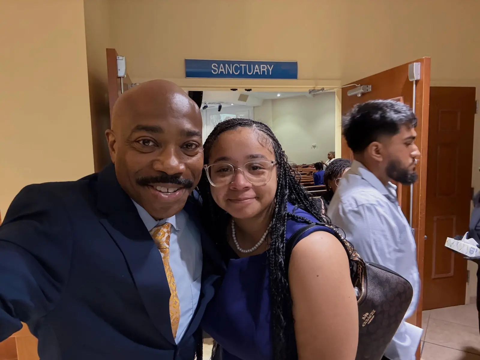 Congregant taking a selfie with pastor in front of the sanctuary