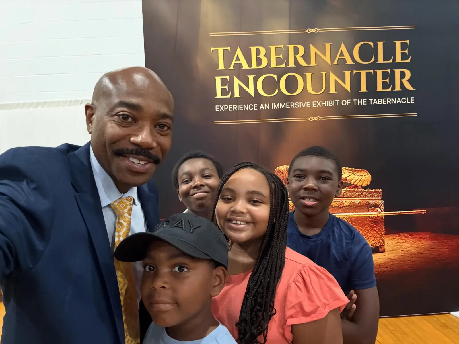 Pastor taking a selfie with children at the Tabernacle Encounter exhibit