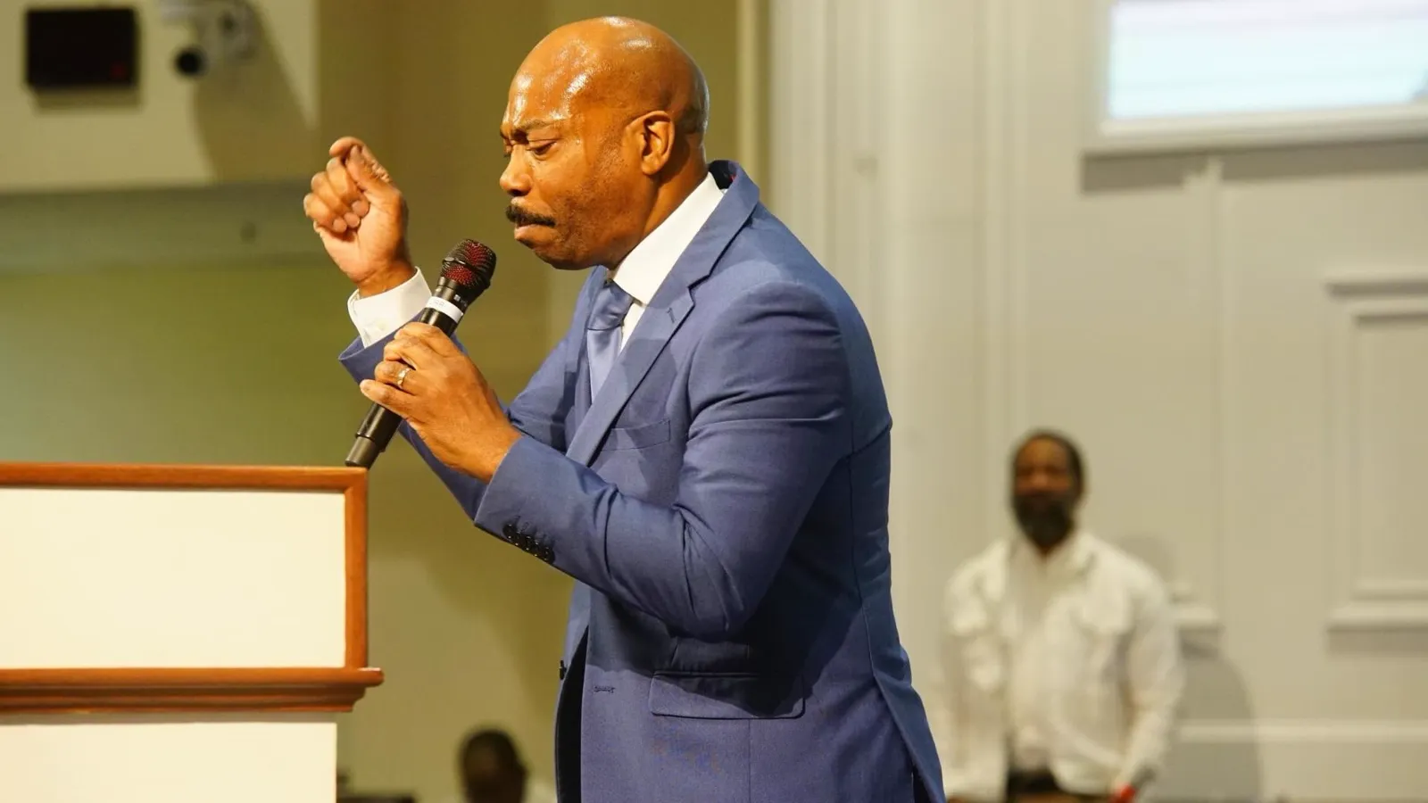Pastor preaching from the pulpit in a blue suit